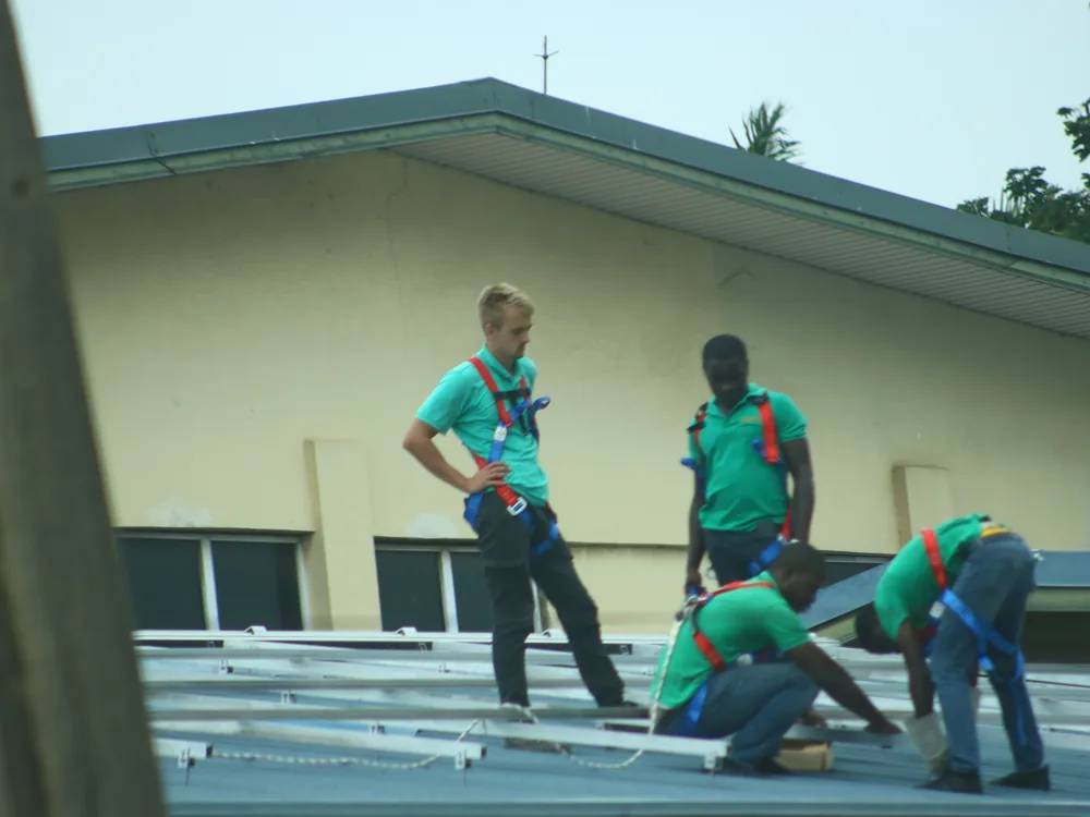 Solar technicians fitting a panel array during an installation